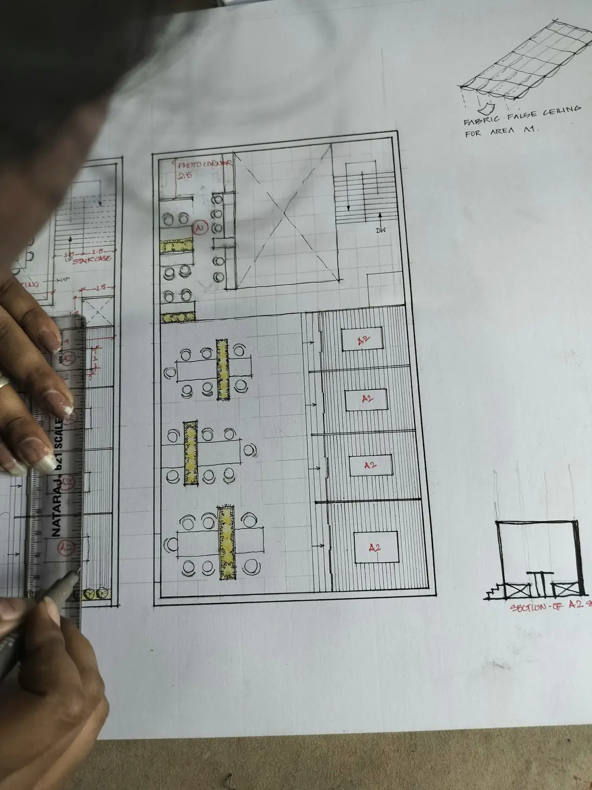 A hand holding a sheet with a drawn floor plan