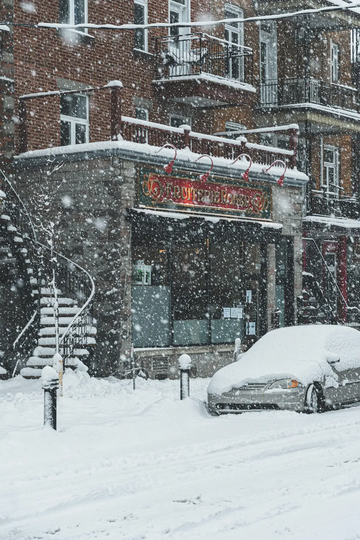 Brick buildings and an exterior staircase during a snowfall