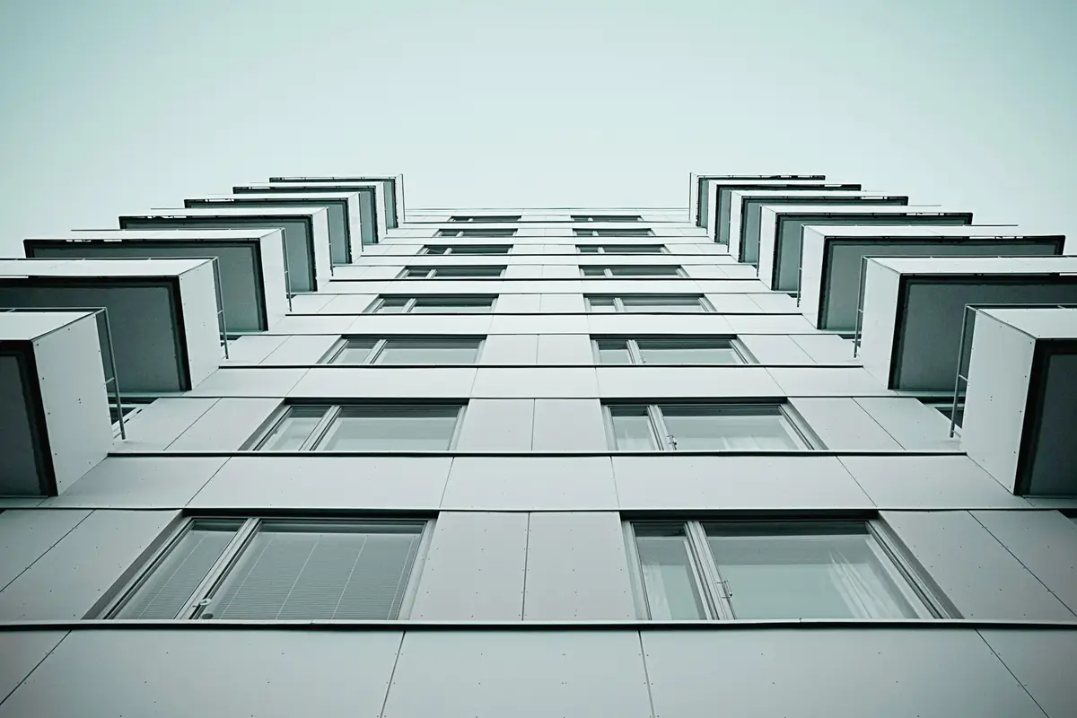 A white apartment facade seen from directly below