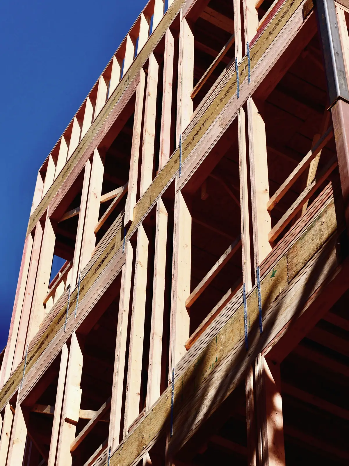 A wood-framed building under construction against the sky